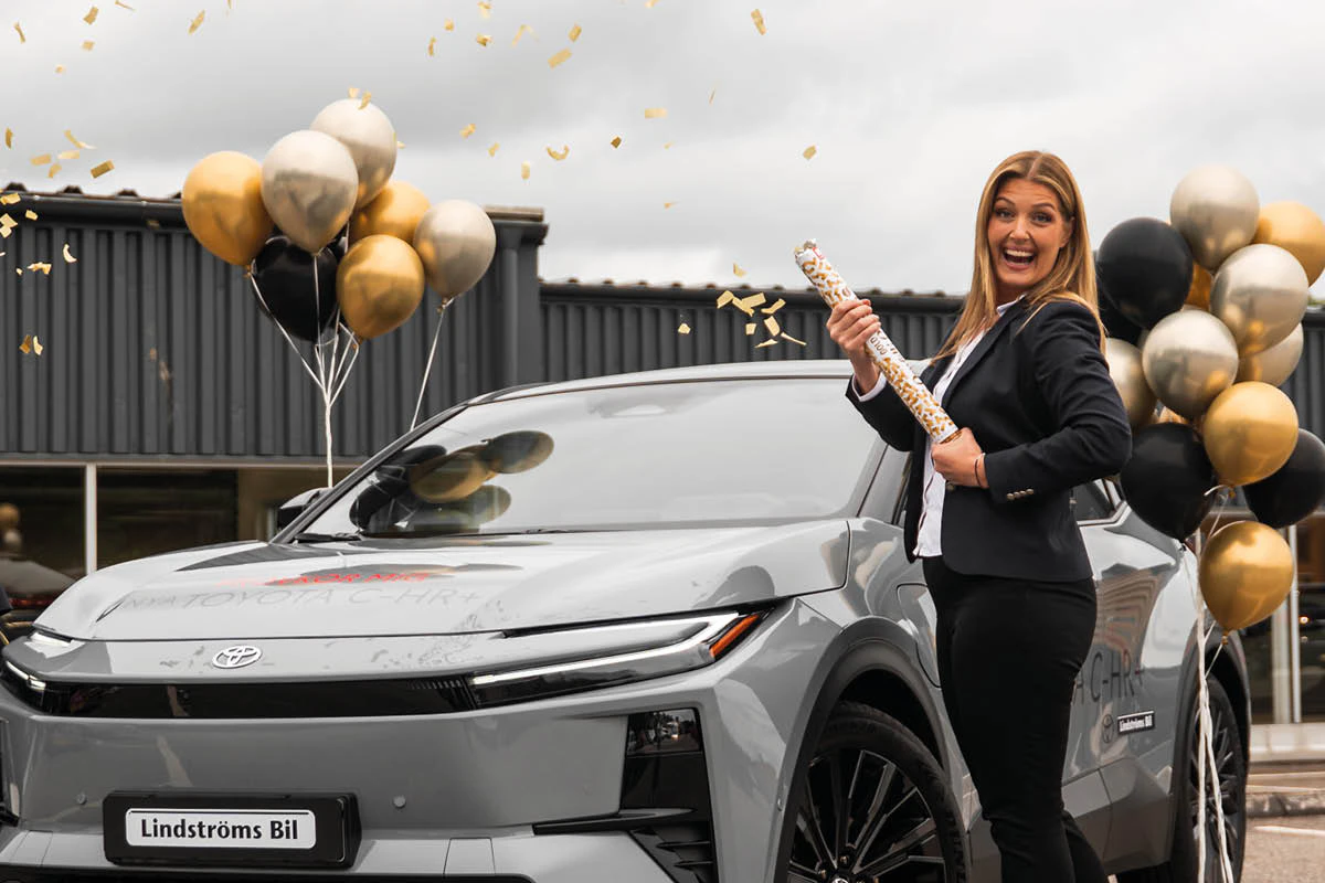 Helena från Lindströms Bil i Trollhättan skjuter av en konfettikanon framför men elbil från Toyota.