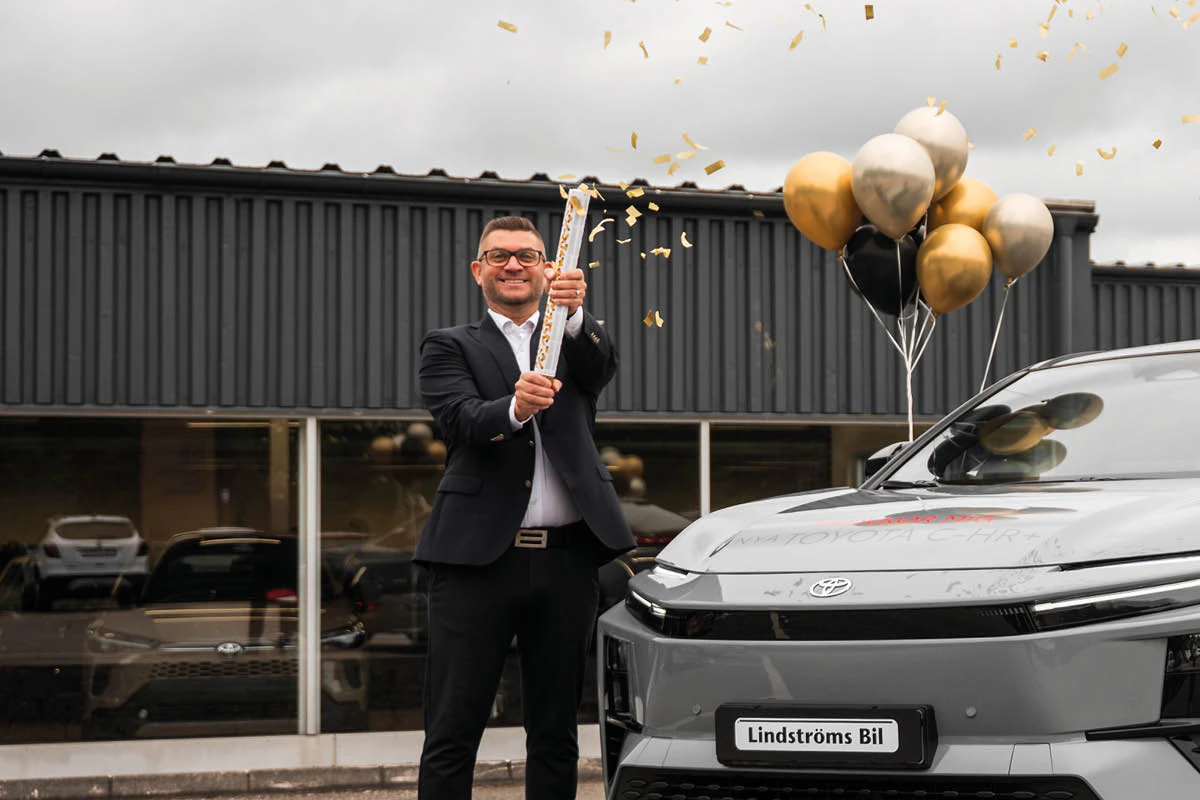 Magnus Normén från Lindströms Bil i Alingsås skjuter av en konfettikanon framför en elbil från Toyota.
