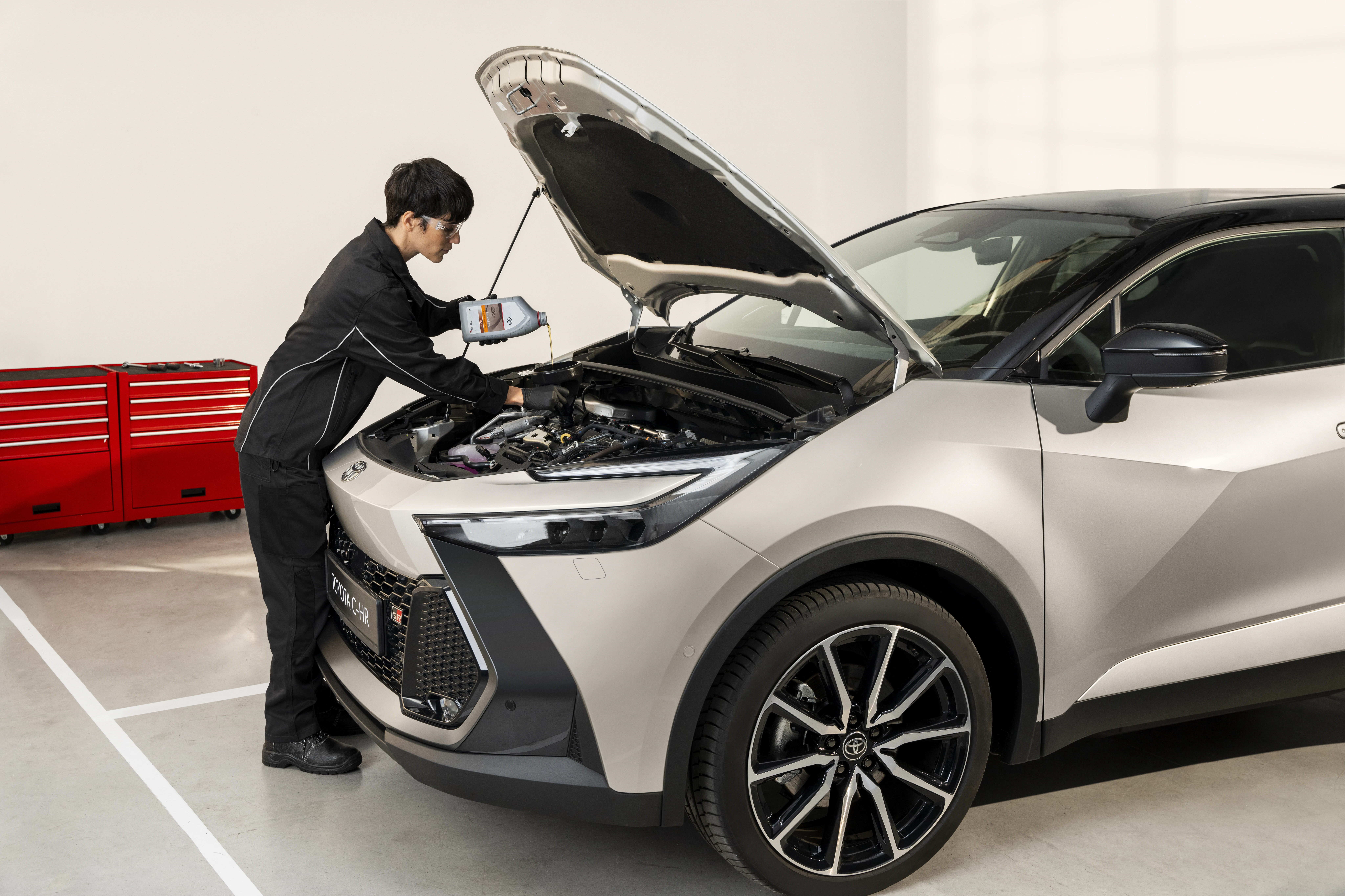 En bild som visar ett oljebyte på en grå Toyota C-HR