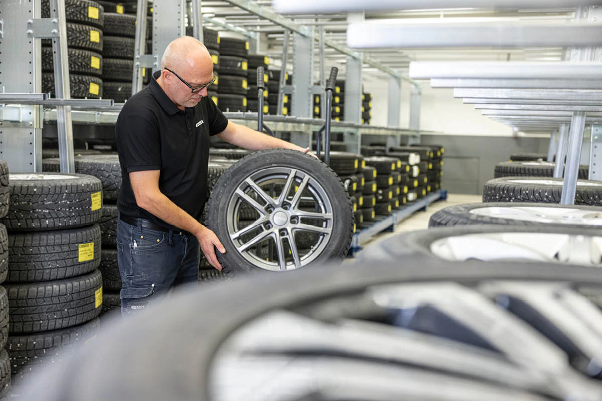 En däckspecialist kontrollerar ett däck innan ett däckbyte.