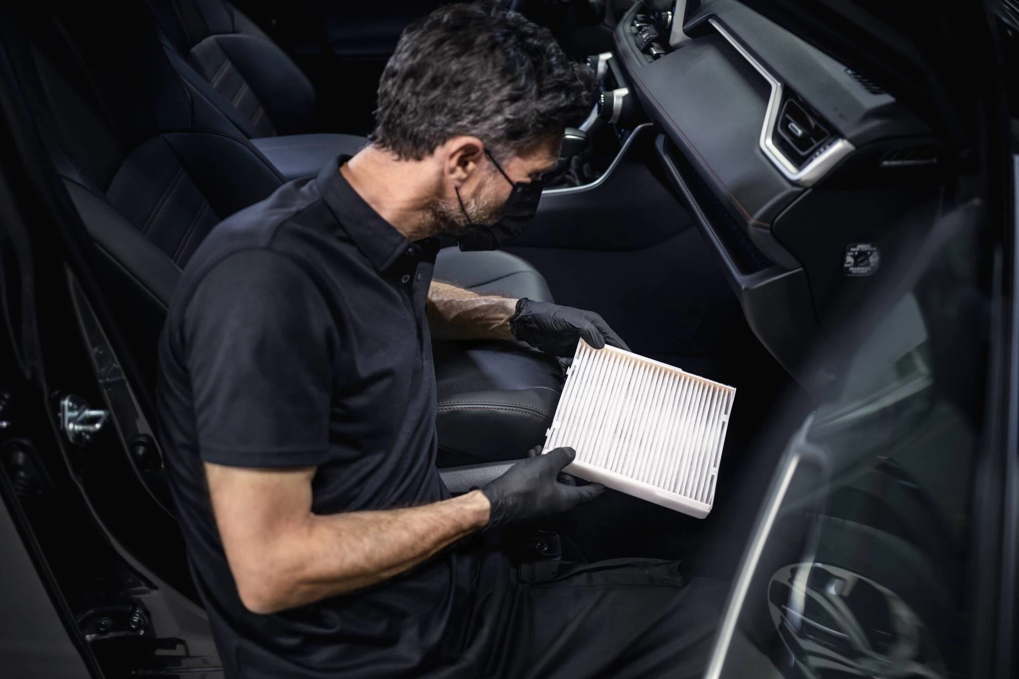 En serviceperson som utför rengöring av ett kupefilter på en Toyota