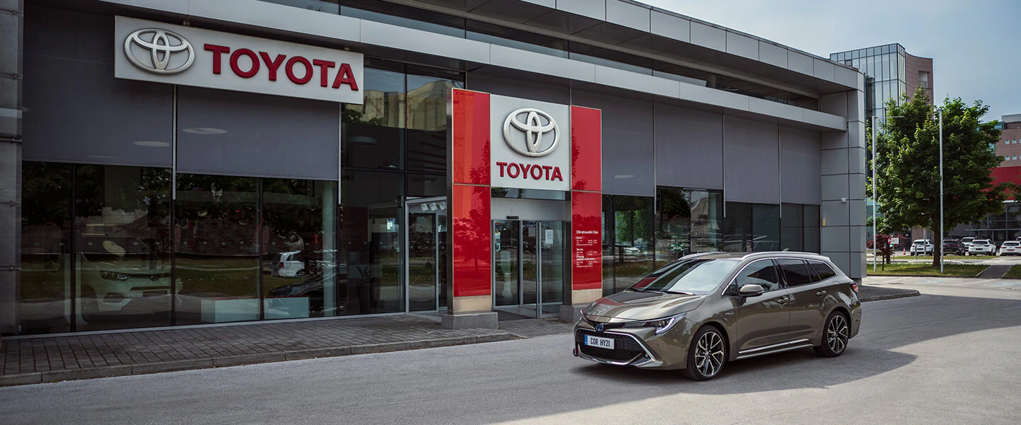 En bronsfärgad Corolla Touring Sports parkerad utanför en Toyota återförsäljare