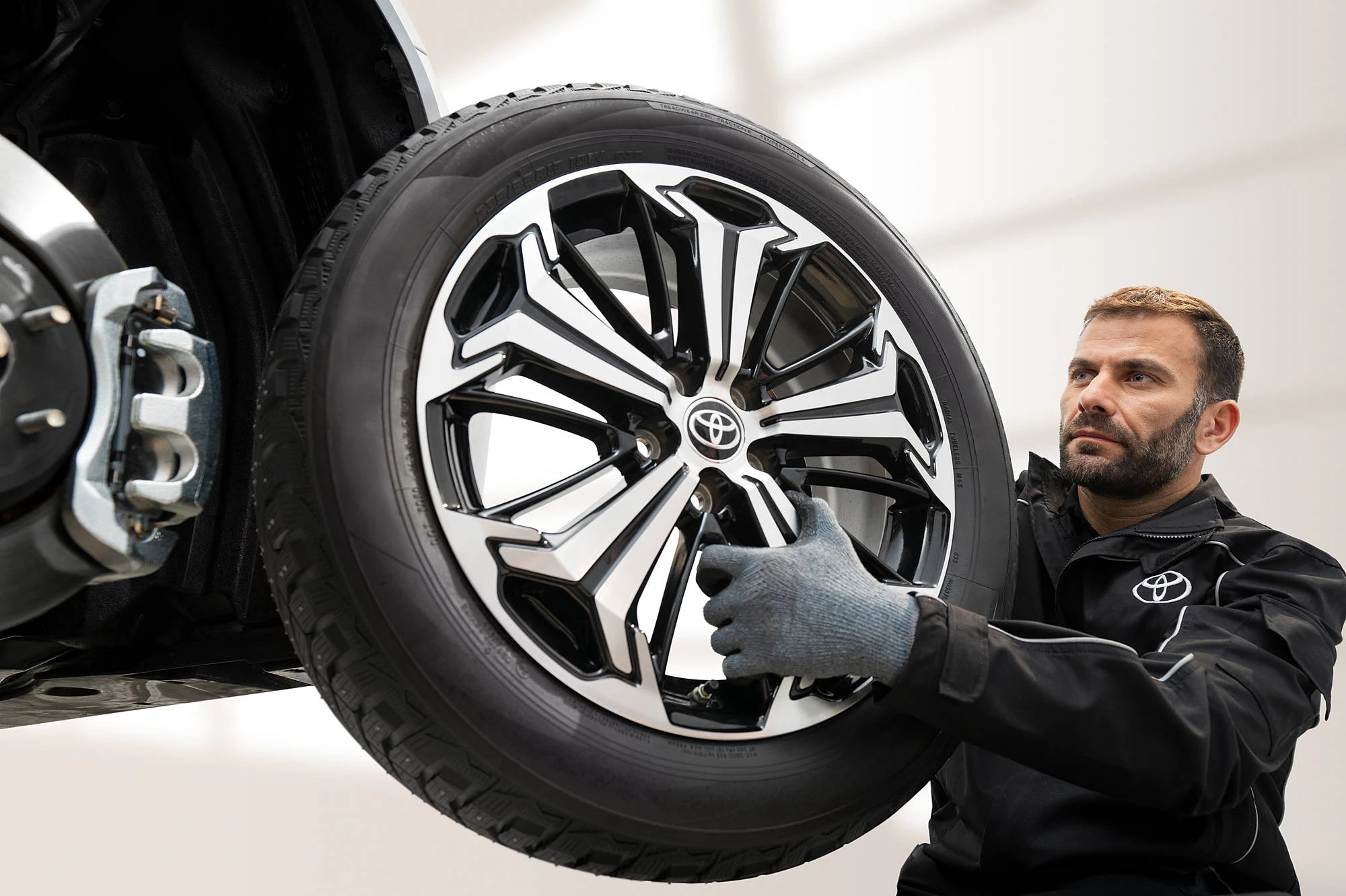 En servicetekniker som byter däcl på en Toyota
