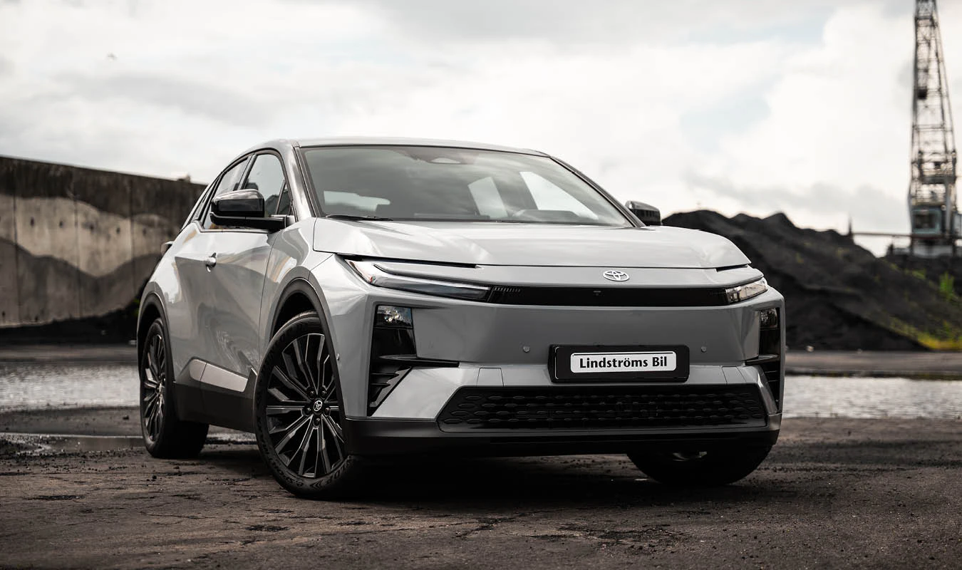 En Toyota C-HR+ står parkerad i ett hamnområde.