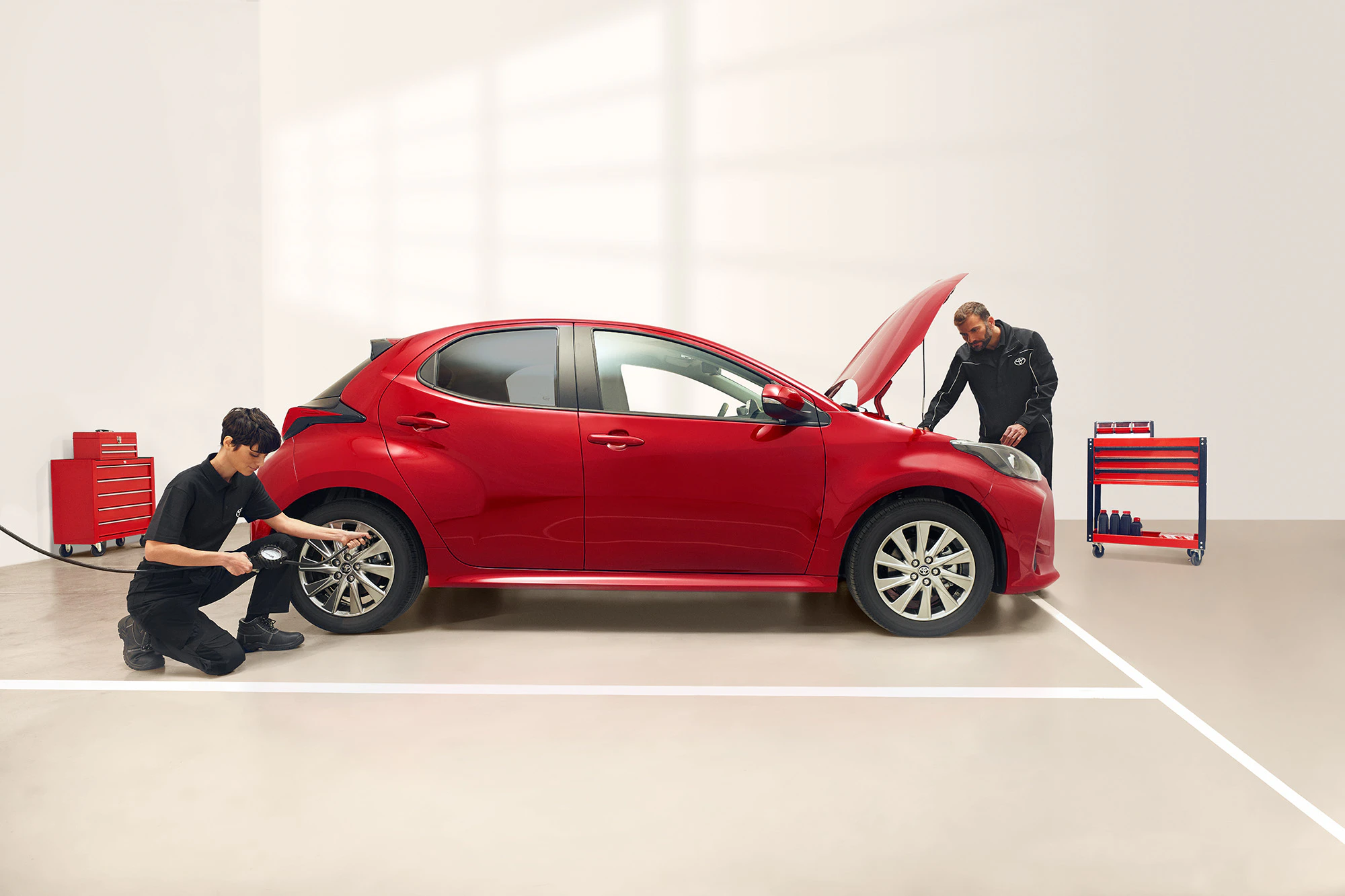 Två servicetekniker som utför service på en röd Toyota