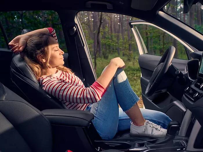 En kvinna som kopplar av i framsätet på en Toyota